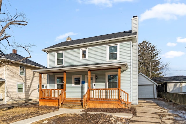 view of front of house featuring a garage, an outdoor structure, and a porch