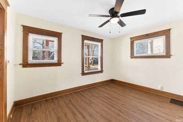 spare room featuring hardwood / wood-style flooring, ceiling fan, and a healthy amount of sunlight