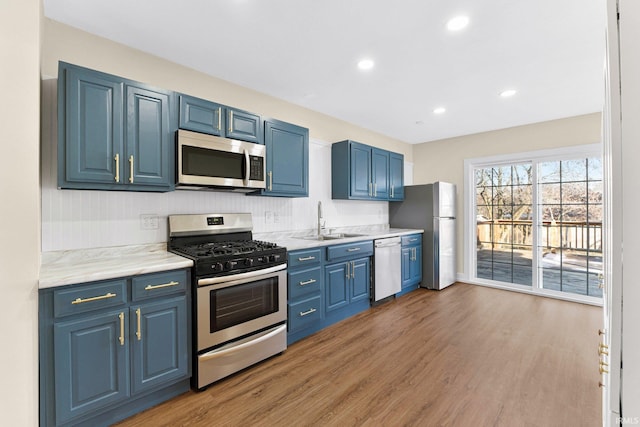 kitchen featuring blue cabinets, appliances with stainless steel finishes, and sink