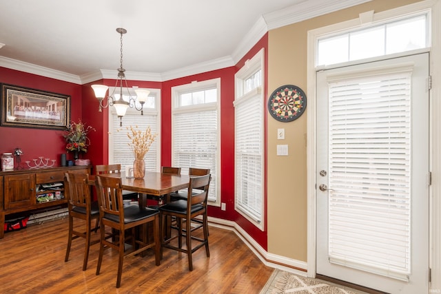 dining space featuring ornamental molding, dark hardwood / wood-style flooring, and a chandelier