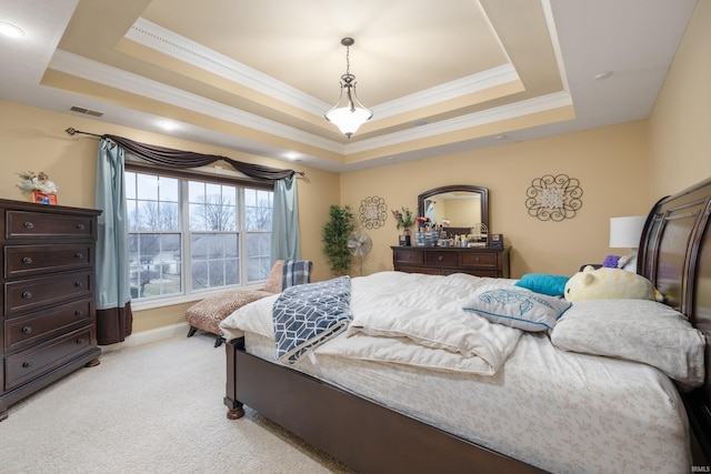 carpeted bedroom with crown molding and a raised ceiling