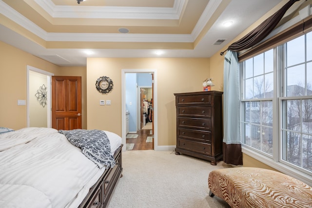 bedroom with crown molding, light colored carpet, and a tray ceiling