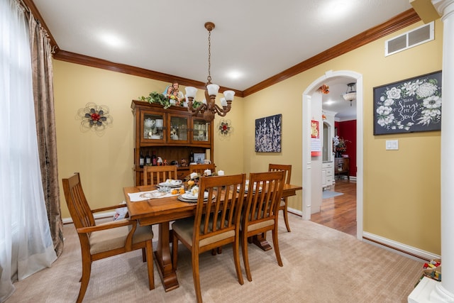 dining room with light carpet and crown molding