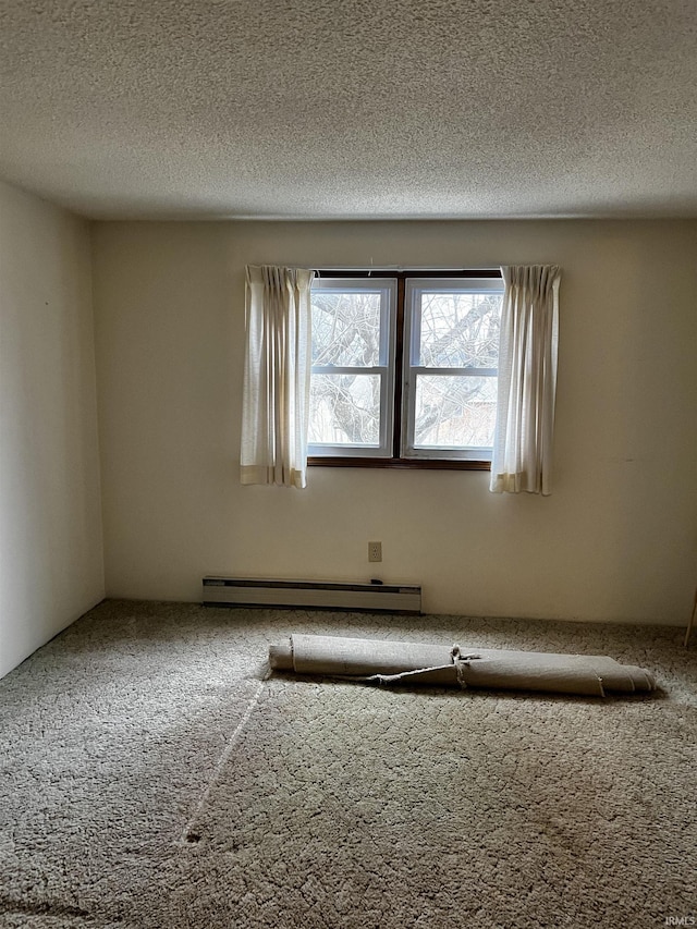 spare room with carpet, a baseboard heating unit, and a textured ceiling