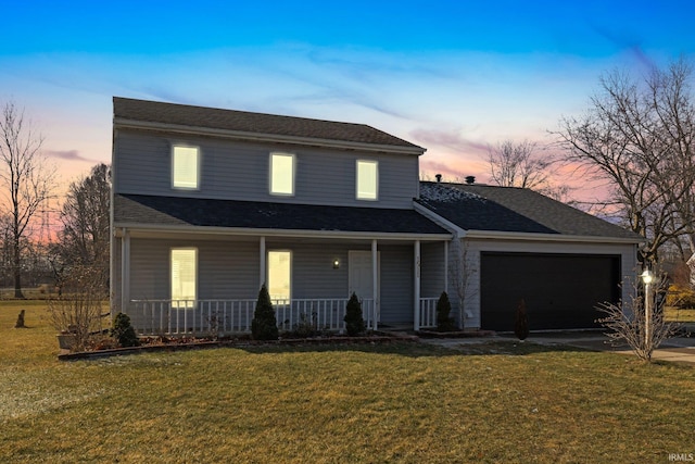 view of front of home with a garage, a yard, and covered porch