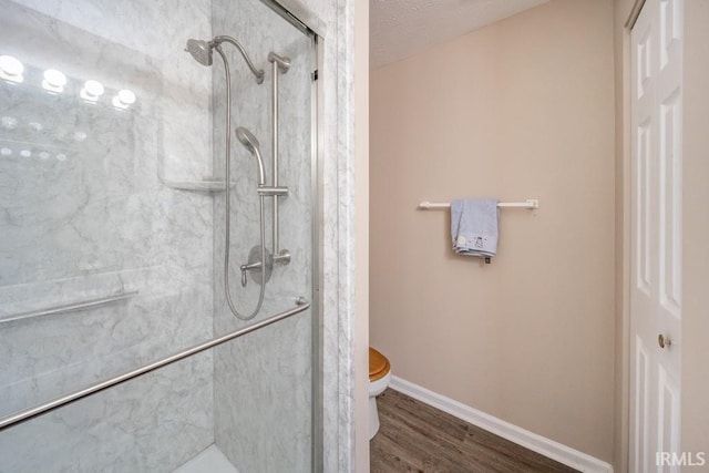 bathroom featuring toilet, wood-type flooring, a textured ceiling, and walk in shower