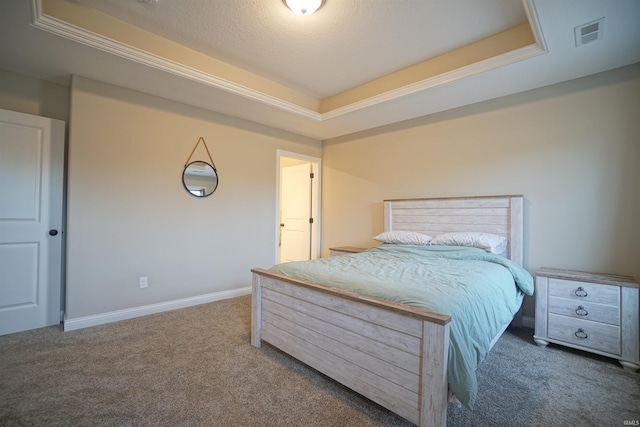 bedroom with a tray ceiling and dark colored carpet