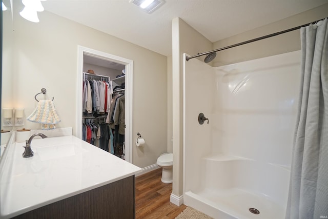 bathroom featuring a shower with curtain, toilet, sink, and hardwood / wood-style flooring