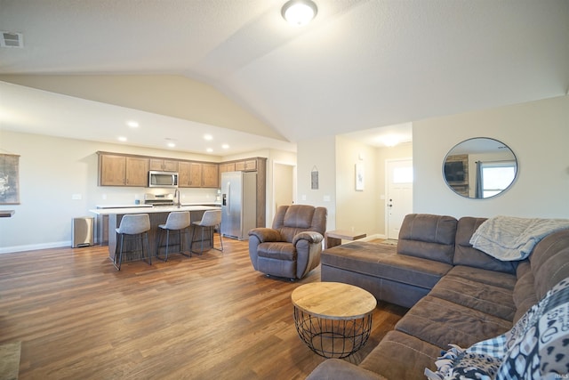 living room featuring dark hardwood / wood-style flooring and vaulted ceiling