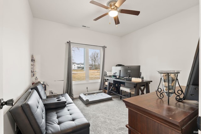 carpeted home office featuring ceiling fan