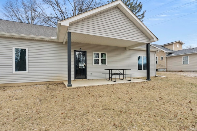 back of property with a yard and a patio