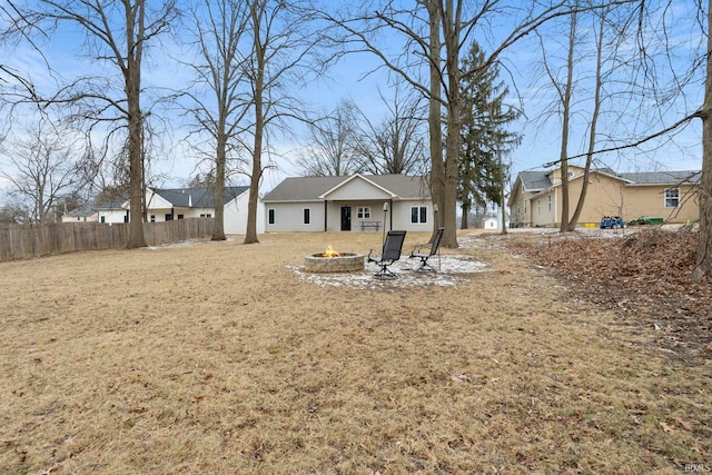 back of property featuring a yard and an outdoor fire pit