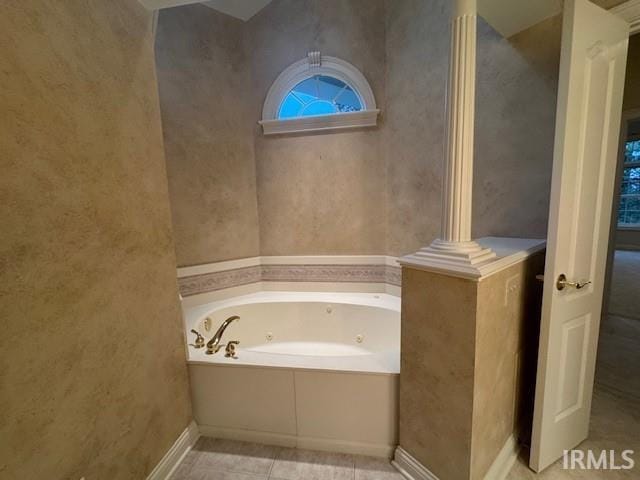 bathroom with tile patterned flooring and a bath