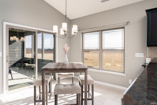 tiled dining room with an inviting chandelier, a healthy amount of sunlight, and lofted ceiling