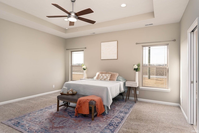 bedroom featuring a tray ceiling, ceiling fan, and carpet