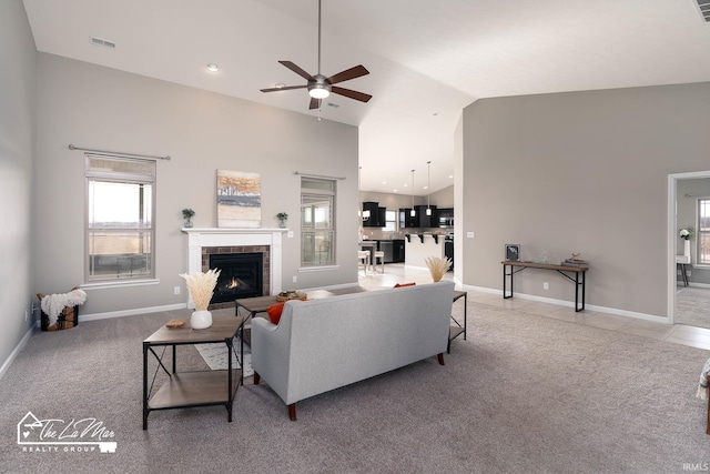 carpeted living room featuring ceiling fan, a fireplace, and high vaulted ceiling