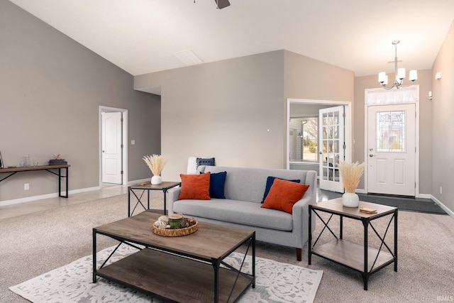 carpeted living room featuring lofted ceiling and a chandelier