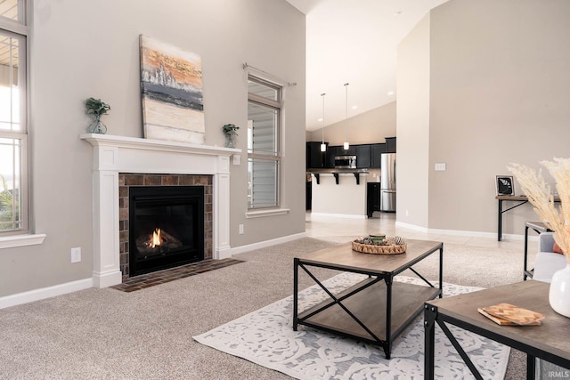 living room with carpet flooring, a healthy amount of sunlight, a fireplace, and high vaulted ceiling