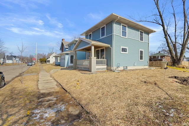 back of property featuring covered porch