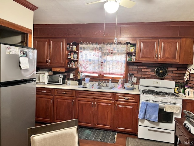 kitchen featuring ceiling fan, sink, stainless steel fridge, and white gas range
