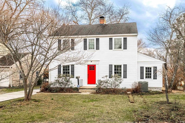 colonial home featuring a front yard and cooling unit