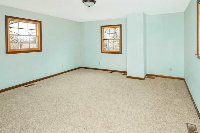 empty room with light carpet and a wealth of natural light