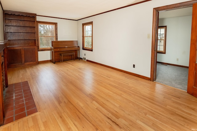 unfurnished living room with ornamental molding and light hardwood / wood-style flooring