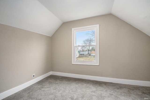 bonus room with lofted ceiling and carpet flooring