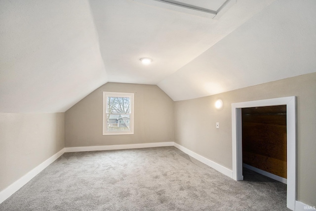 additional living space with vaulted ceiling and carpet flooring