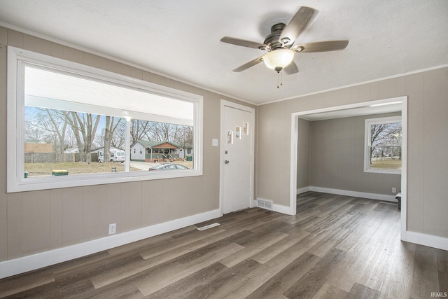 foyer featuring crown molding, dark wood-type flooring, a wealth of natural light, and ceiling fan