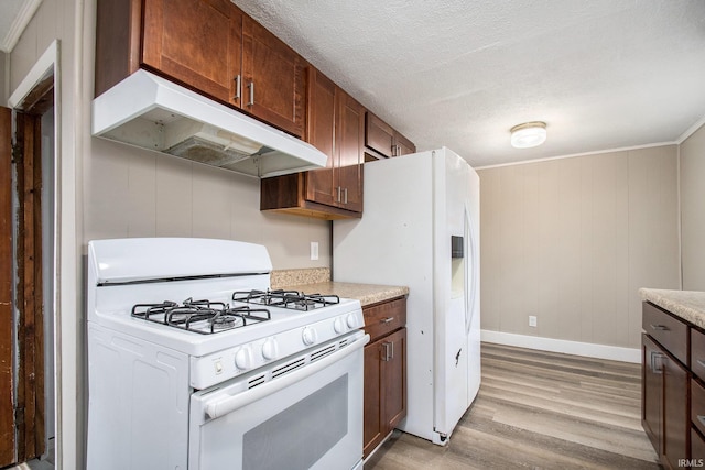 kitchen with white appliances, ornamental molding, light hardwood / wood-style floors, and a textured ceiling