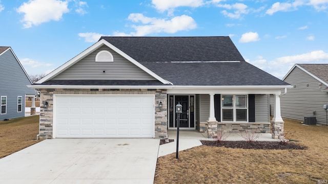 view of front facade with a garage, central AC, a front yard, and covered porch