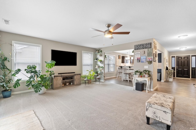 carpeted living room with ceiling fan