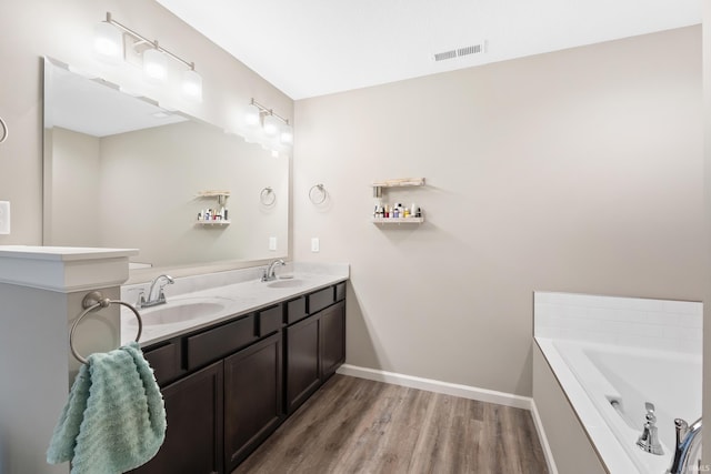 bathroom featuring hardwood / wood-style flooring, vanity, and a bathtub