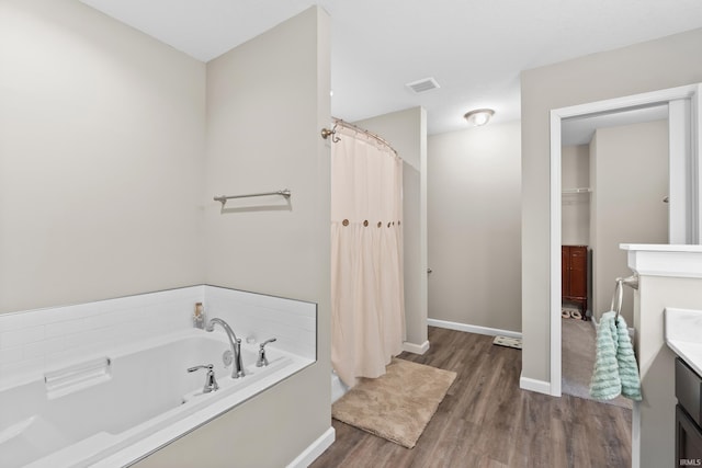 bathroom featuring wood-type flooring, vanity, and a bathtub