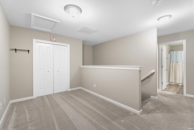 interior space with light colored carpet and a textured ceiling