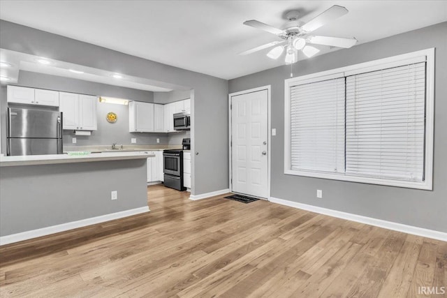 kitchen with white cabinetry, appliances with stainless steel finishes, sink, and light hardwood / wood-style floors