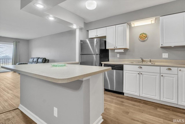 kitchen with sink, stainless steel appliances, light hardwood / wood-style floors, and white cabinets