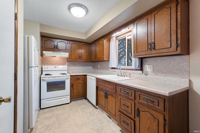 kitchen with white appliances, sink, and backsplash