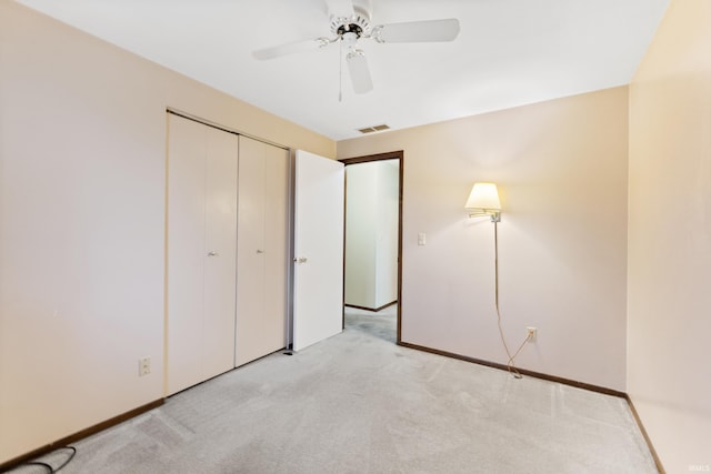 unfurnished bedroom featuring light carpet, a closet, and ceiling fan