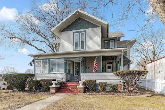 view of front of home featuring a front lawn, a sunroom, and covered porch