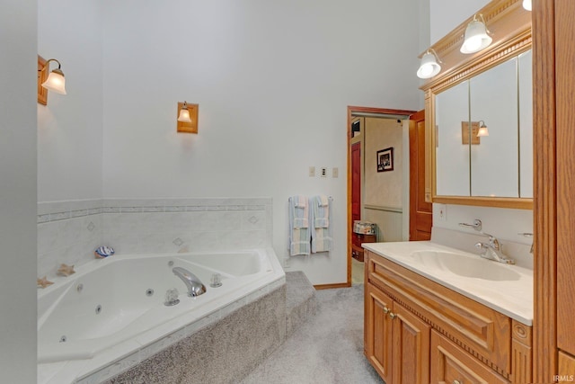 bathroom featuring tiled tub and vanity