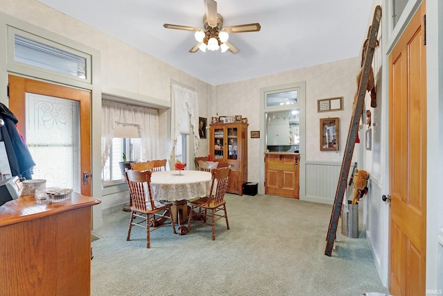 carpeted dining area with ceiling fan