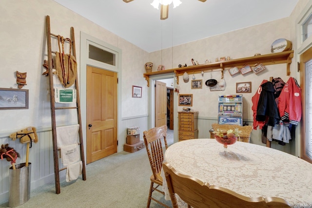 carpeted dining room with ceiling fan