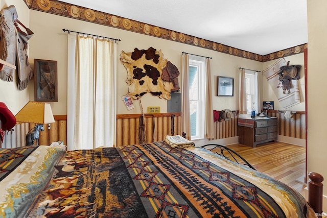 bedroom with electric panel and light wood-type flooring