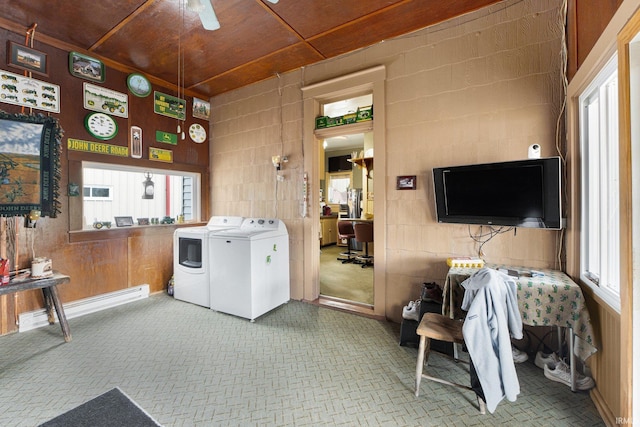 clothes washing area featuring a healthy amount of sunlight, washer and dryer, ceiling fan, and a baseboard radiator