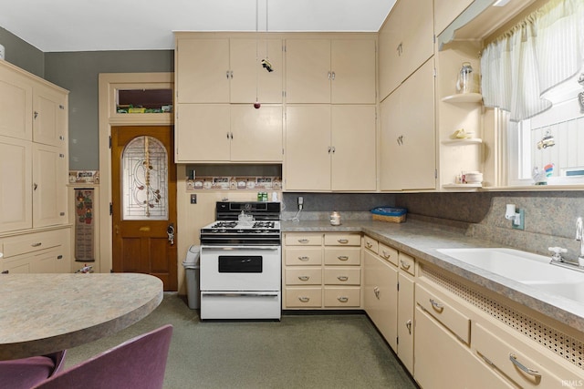 kitchen featuring tasteful backsplash, sink, white gas range oven, and cream cabinetry