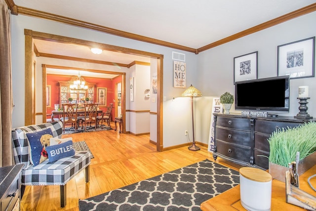 living room with an inviting chandelier, hardwood / wood-style flooring, and ornamental molding