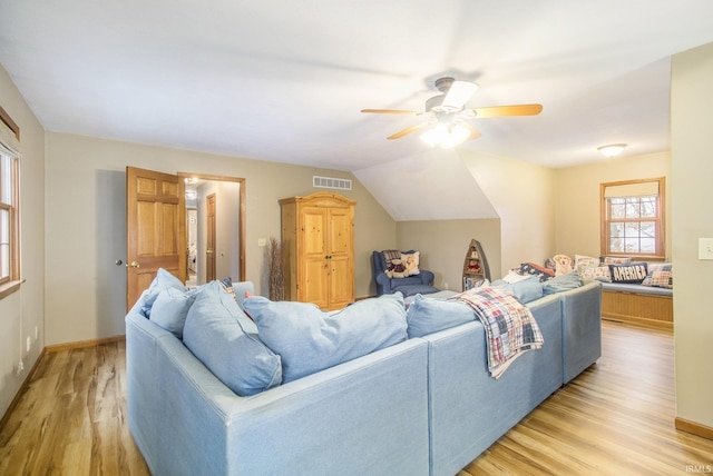 living room featuring ceiling fan, lofted ceiling, and light wood-type flooring