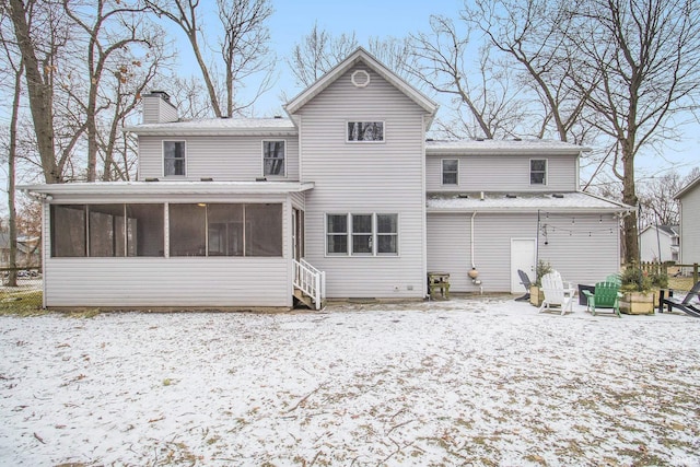 snow covered property featuring a sunroom